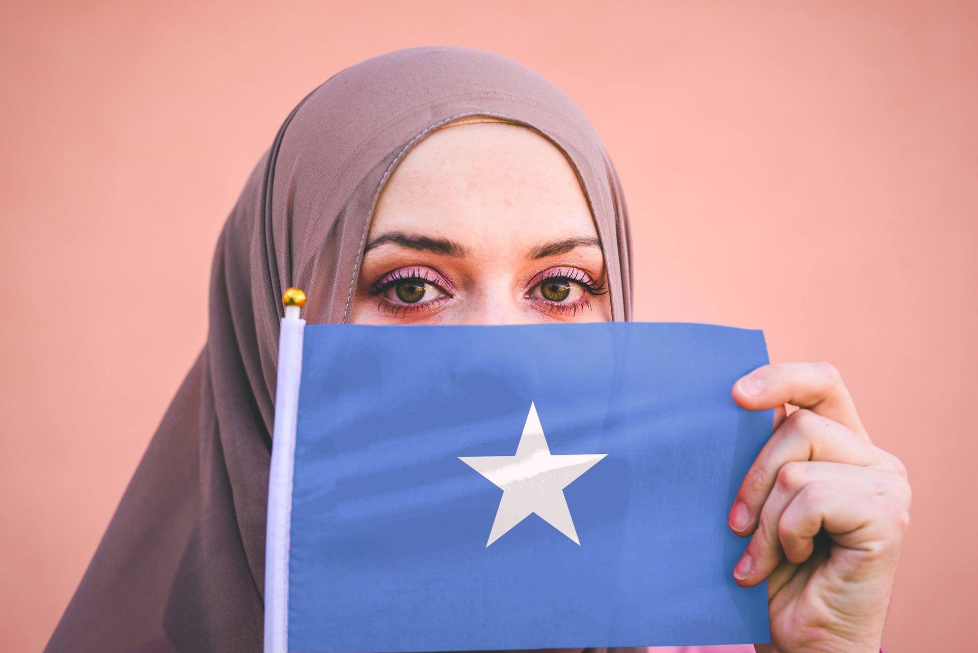 Muslim woman in hijab holds flag of Somalia